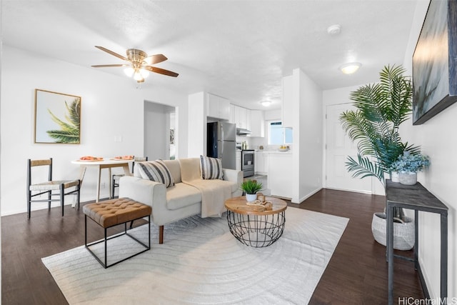 living room with ceiling fan, dark wood-type flooring, and a textured ceiling