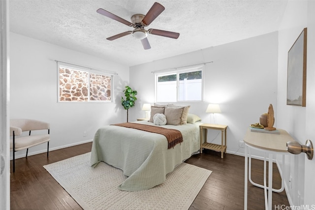 bedroom featuring a textured ceiling, ceiling fan, and dark hardwood / wood-style floors