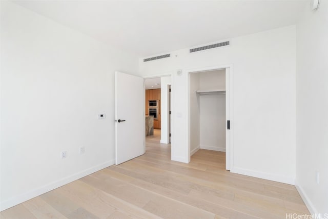 unfurnished bedroom featuring a closet and light hardwood / wood-style flooring