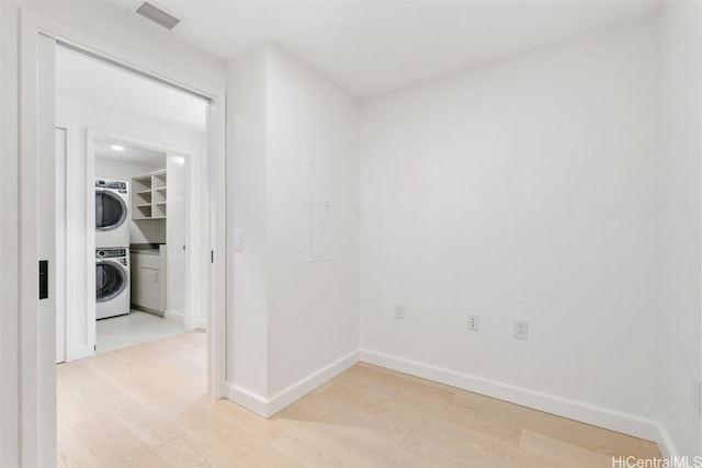 interior space with light wood-type flooring and stacked washer and dryer