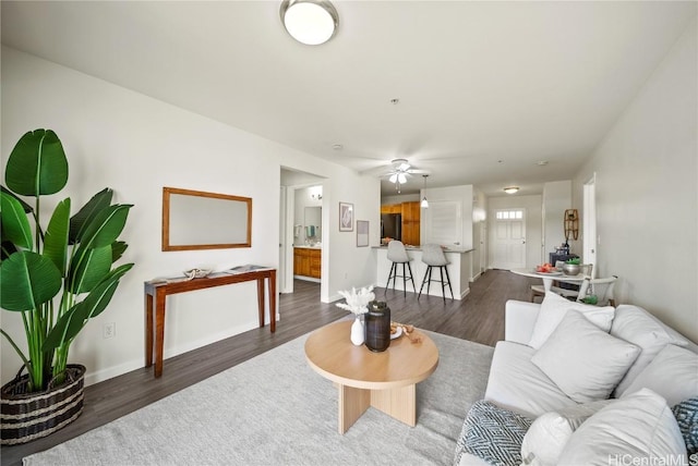 living room featuring ceiling fan and dark hardwood / wood-style flooring