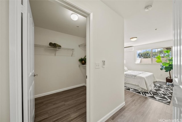 walk in closet with hardwood / wood-style floors and a wall mounted air conditioner