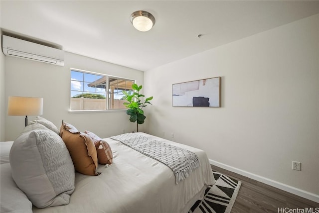 bedroom featuring dark hardwood / wood-style flooring and a wall unit AC