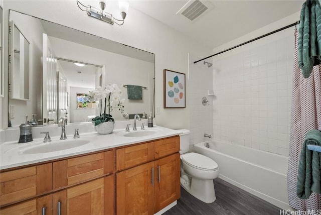 full bathroom featuring vanity, hardwood / wood-style flooring, toilet, and tiled shower / bath