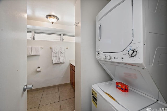 washroom featuring light tile patterned floors and stacked washer and clothes dryer