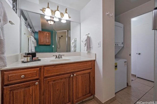 bathroom featuring tile patterned flooring, vanity, a shower, and stacked washer / dryer