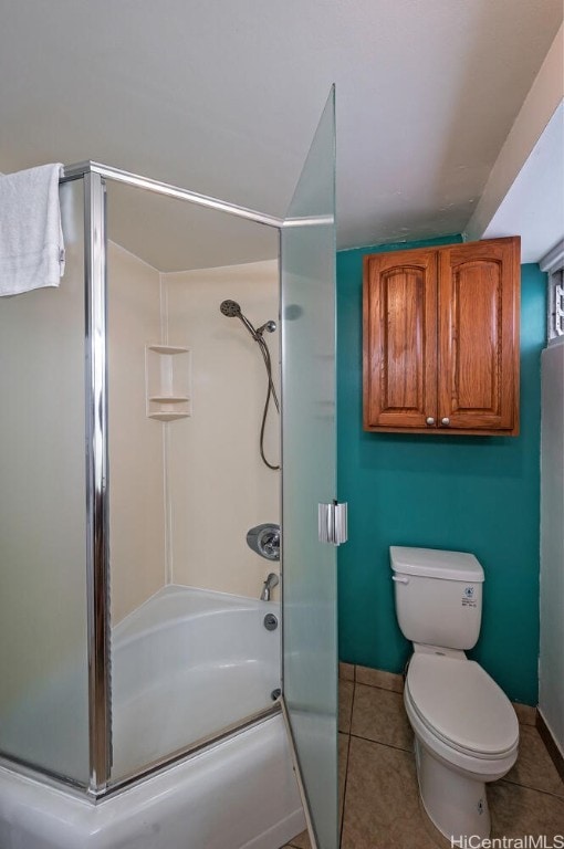 bathroom featuring tile patterned flooring, toilet, and enclosed tub / shower combo