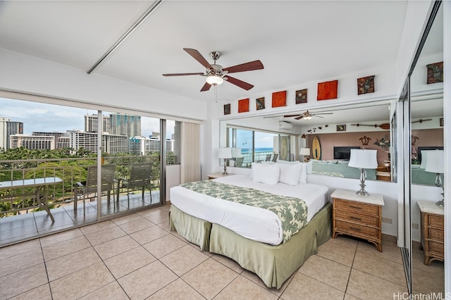 bedroom with access to exterior, light tile patterned floors, multiple windows, and ceiling fan