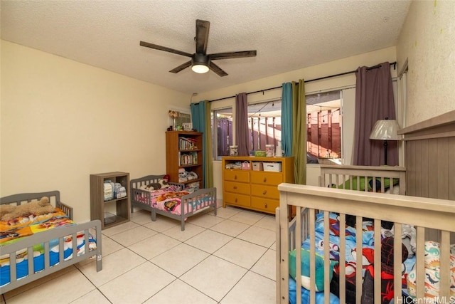 bedroom featuring light tile patterned floors, a textured ceiling, and ceiling fan