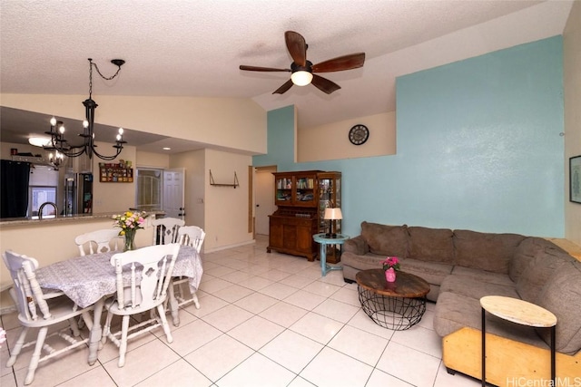 tiled dining area with a textured ceiling, sink, ceiling fan with notable chandelier, and vaulted ceiling