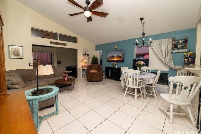 dining space featuring light tile patterned floors, ceiling fan with notable chandelier, a textured ceiling, and vaulted ceiling