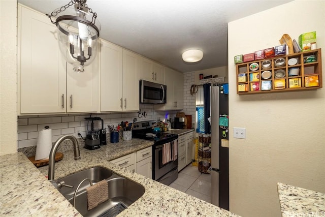 kitchen featuring sink, white cabinetry, stainless steel appliances, and tasteful backsplash