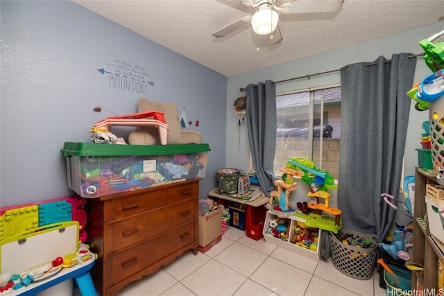 game room featuring ceiling fan, light tile patterned floors, and a textured ceiling