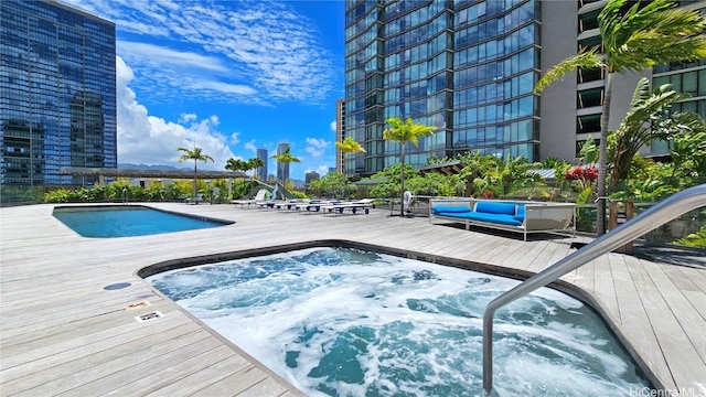 view of pool with a community hot tub and a deck