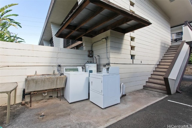 clothes washing area featuring sink and washer and clothes dryer