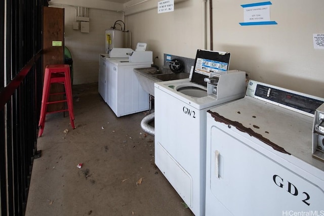 laundry room featuring gas water heater, washer and clothes dryer, and sink