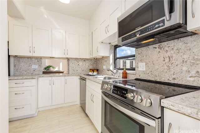 kitchen with white cabinets, appliances with stainless steel finishes, tasteful backsplash, and sink