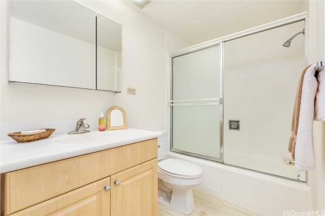 full bathroom featuring vanity, toilet, and bath / shower combo with glass door