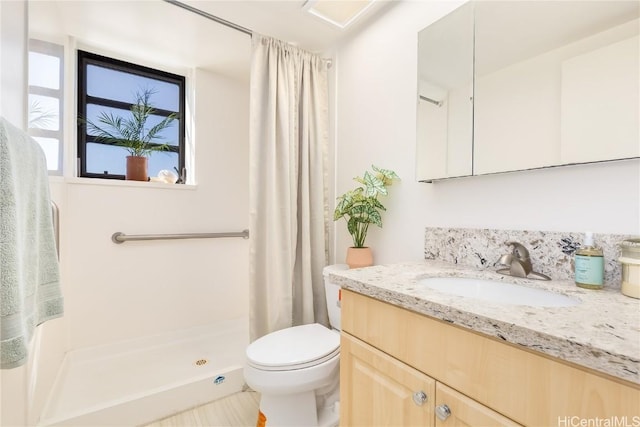 bathroom featuring tile patterned floors, vanity, toilet, and walk in shower