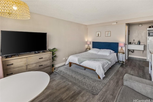 bedroom featuring a textured ceiling, dark hardwood / wood-style floors, and sink