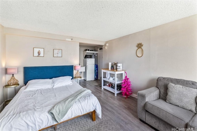 bedroom with hardwood / wood-style floors and a textured ceiling