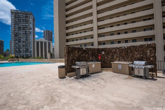 view of pool with a patio area and grilling area