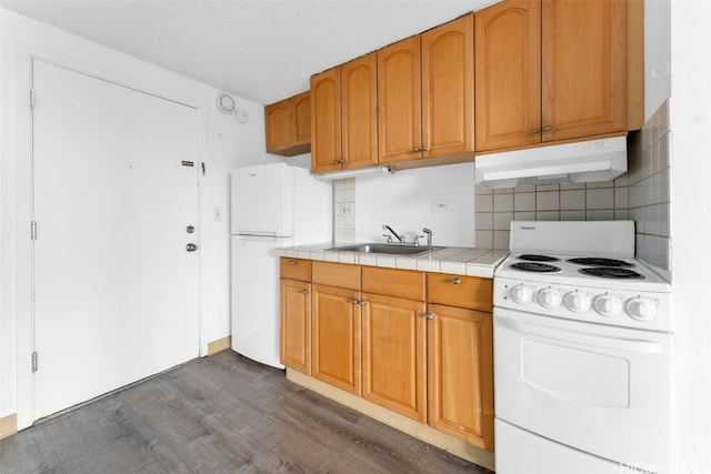 kitchen featuring tile countertops, white appliances, dark wood-type flooring, sink, and tasteful backsplash