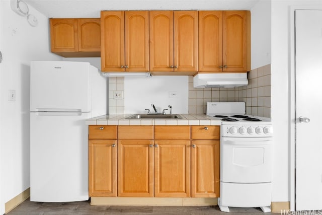 kitchen with tile countertops, white appliances, tasteful backsplash, and sink