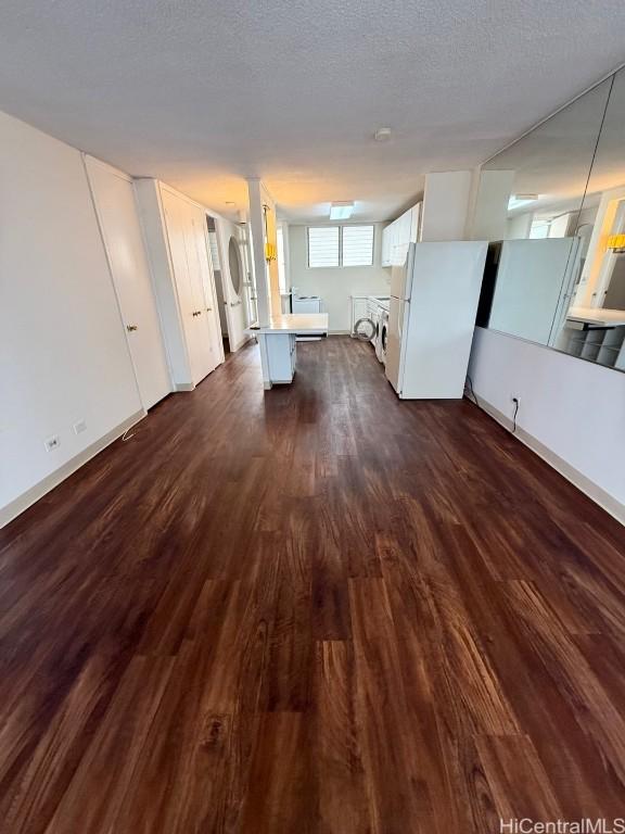 unfurnished living room featuring dark hardwood / wood-style floors and a textured ceiling