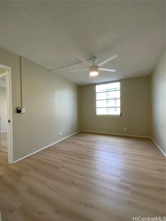 empty room featuring ceiling fan, a textured ceiling, and light wood-type flooring