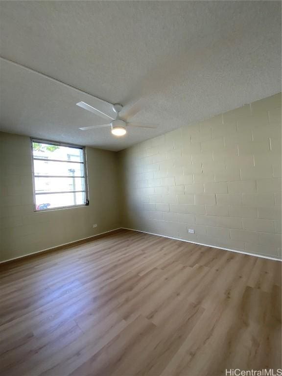 unfurnished room featuring a textured ceiling and light wood-type flooring