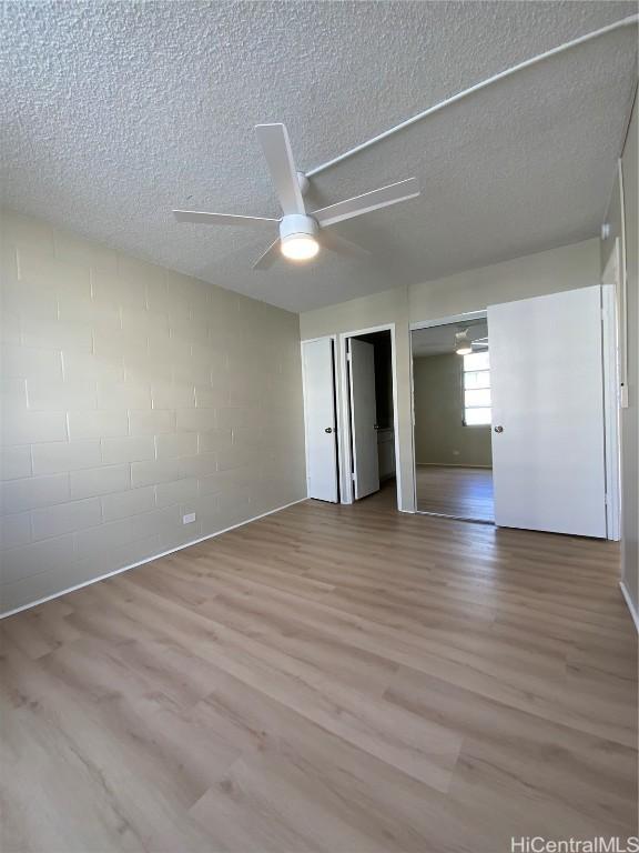 unfurnished bedroom with ceiling fan, light hardwood / wood-style flooring, and a textured ceiling