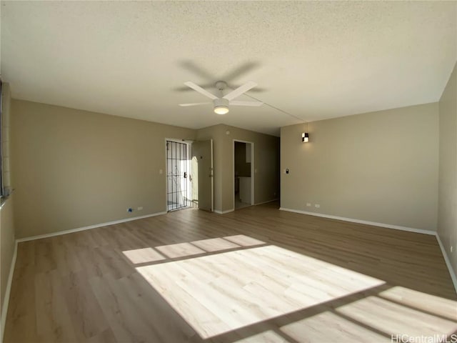 unfurnished room featuring ceiling fan, light hardwood / wood-style floors, and a textured ceiling