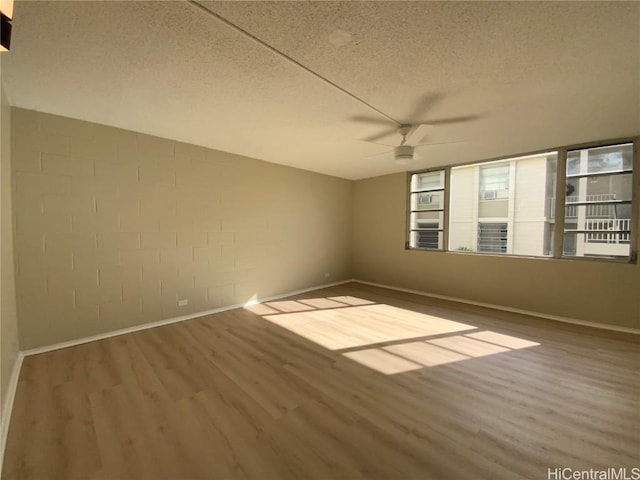 spare room featuring ceiling fan, hardwood / wood-style floors, and a textured ceiling