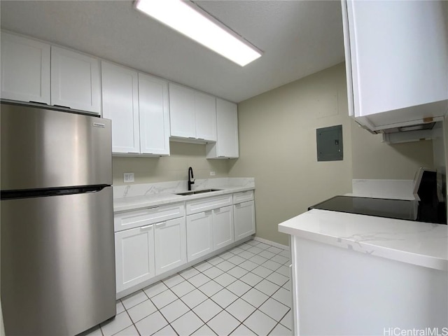 kitchen featuring electric panel, white cabinets, sink, range, and stainless steel refrigerator