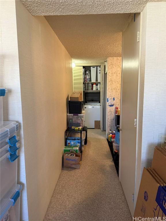 corridor with carpet floors and a textured ceiling