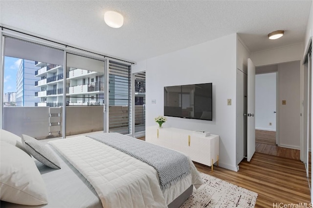 bedroom with a textured ceiling and hardwood / wood-style flooring