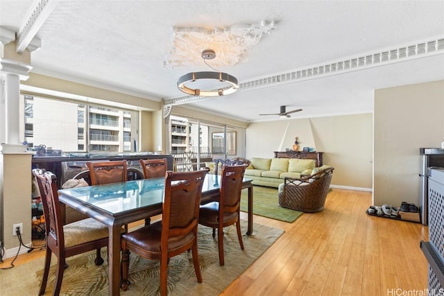 dining area with ornate columns, baseboards, ceiling fan, and hardwood / wood-style flooring