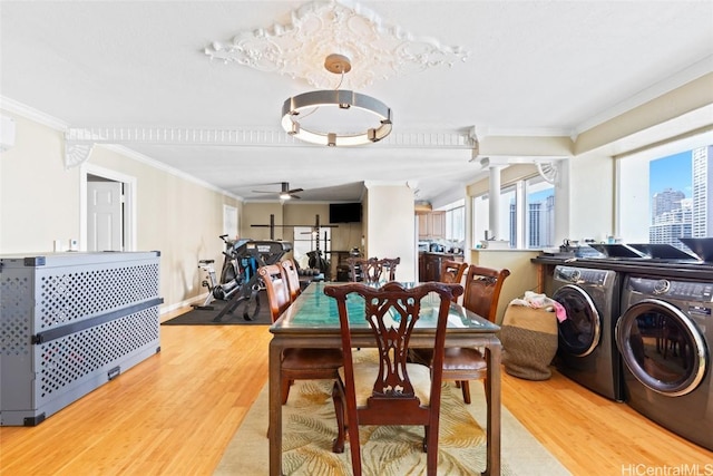 dining space featuring light wood-style floors, independent washer and dryer, ornamental molding, and a ceiling fan