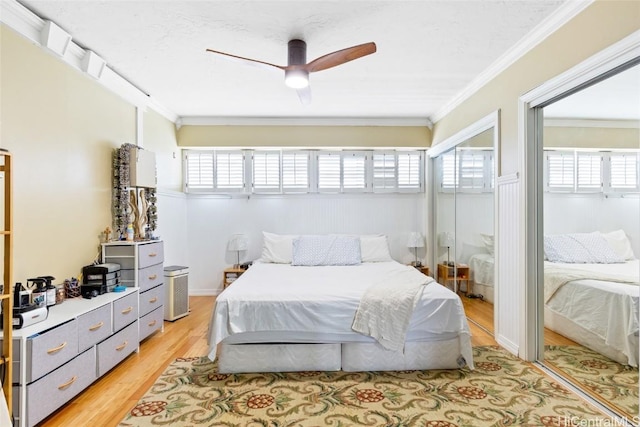 bedroom with ceiling fan, multiple windows, light wood-style floors, and ornamental molding