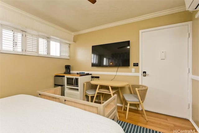 bedroom with wood finished floors and ornamental molding