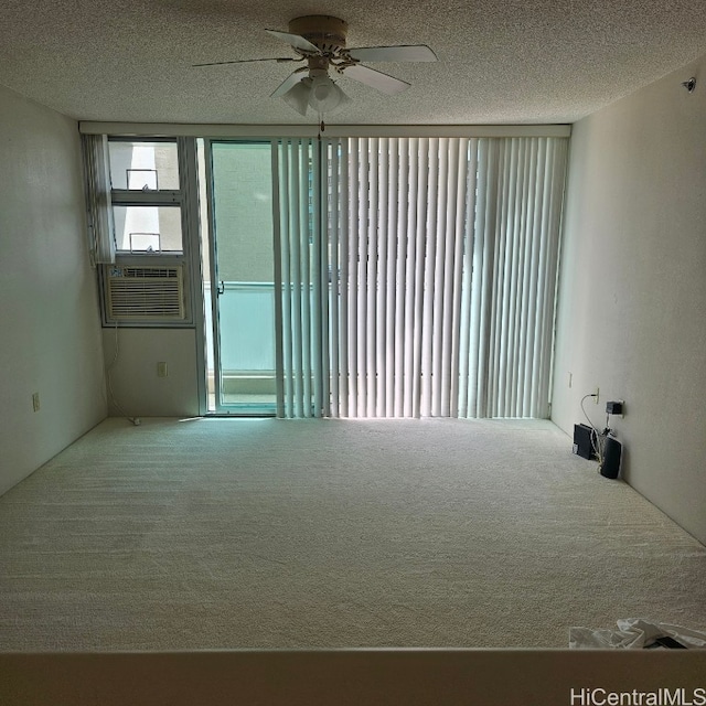 unfurnished room with cooling unit, ceiling fan, a textured ceiling, and carpet floors