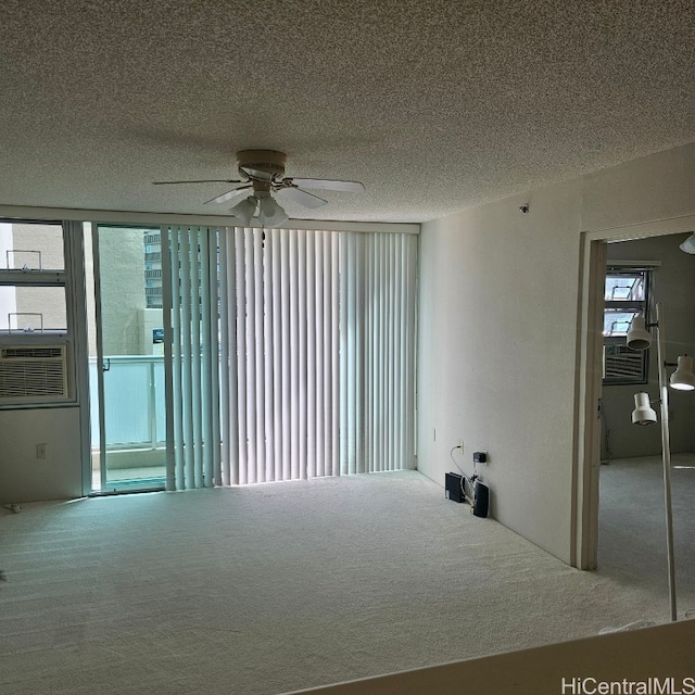 carpeted empty room featuring a textured ceiling, cooling unit, and ceiling fan