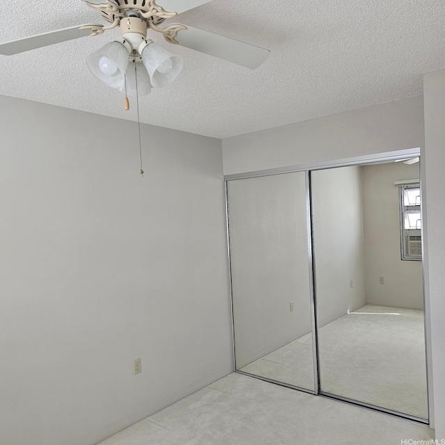 3009 Ala Makahala Pl Unit 808, Honolulu, HI 96818 - unfurnished bedroom featuring carpet floors, a textured ceiling, a closet, and a ceiling fan