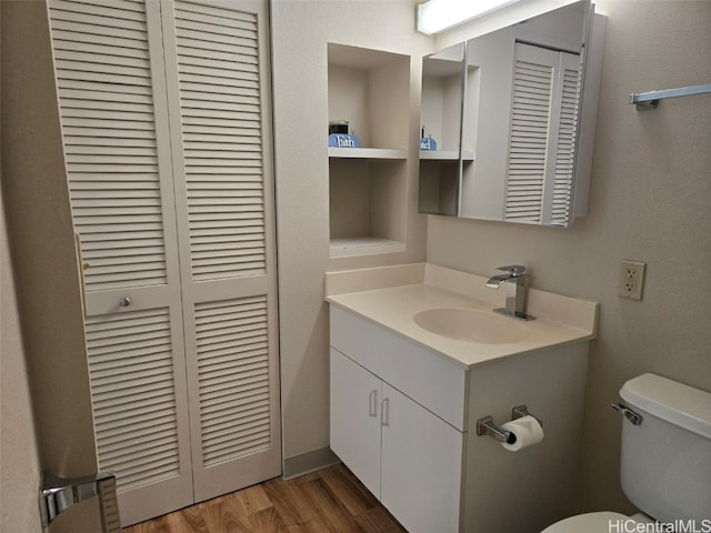 bathroom featuring hardwood / wood-style flooring, toilet, and vanity