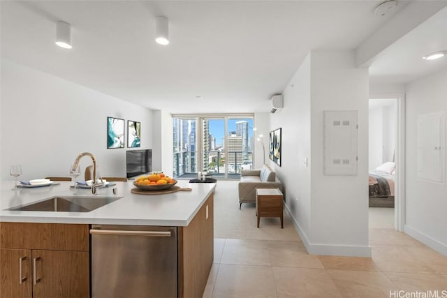 kitchen featuring a wall mounted AC, sink, dishwasher, an island with sink, and light tile patterned flooring