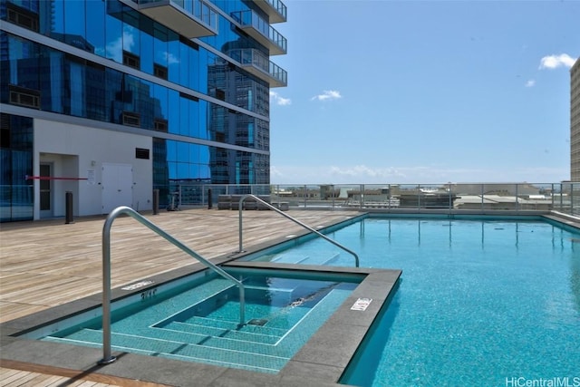 view of swimming pool featuring a hot tub