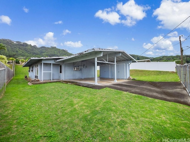 back of property featuring a lawn, a mountain view, and a carport