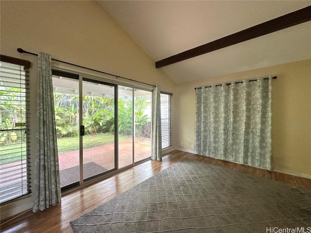 unfurnished room with dark hardwood / wood-style flooring, lofted ceiling with beams, and plenty of natural light