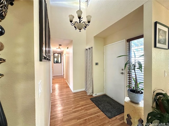 foyer entrance featuring light hardwood / wood-style floors and an inviting chandelier